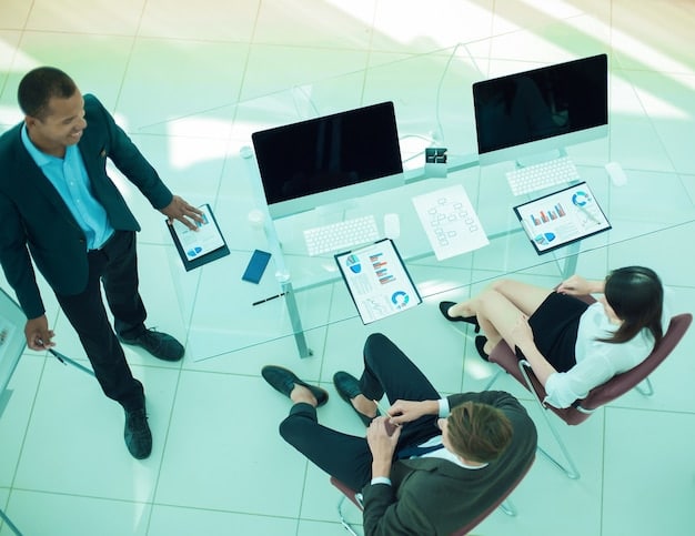 A modern office space with employees collaborating using digital devices such as tablets, laptops, and interactive whiteboards, showcasing a tech-driven environment.