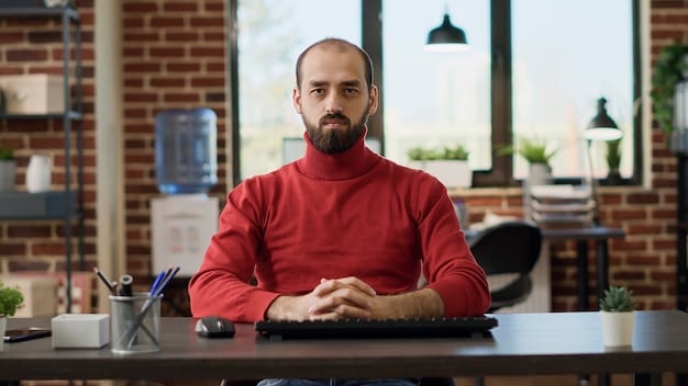 A close-up shot of a remote worker sitting at a standing desk in a coworking space, looking thoughtfully at a dual-monitor setup. The worker is focused and engaged, with noise-canceling headphones on. The background is blurred, showing other people working quietly and plants adding a touch of nature to the environment. The image conveys a sense of concentration and well-being in a modern coworking setting.