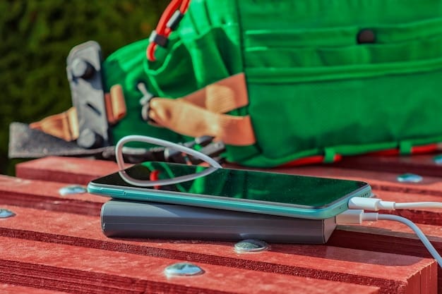 A close-up of a portable power bank charging a smartphone and a laptop simultaneously. The power bank has multiple ports.