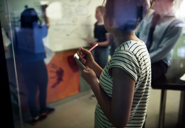 A team using a virtual whiteboard during a remote brainstorming session, with sticky notes representing different ideas and a timeline illustrating project progress. The scene conveys a sense of active participation and innovation among team members in a virtual setting.