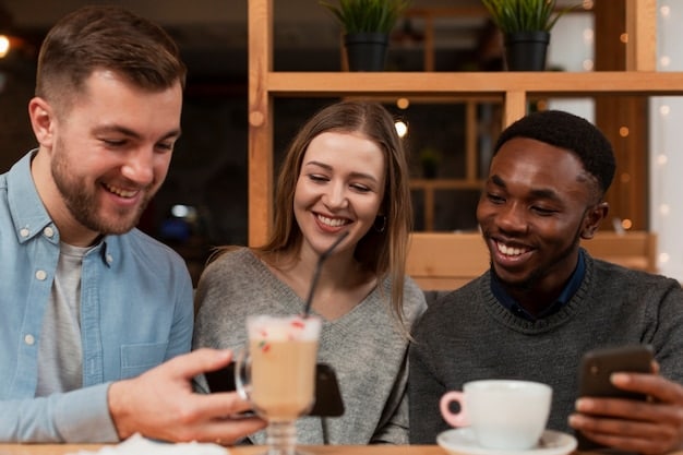 A screenshot of a virtual coffee break, showing remote team members casually chatting and laughing during a video call. Coffee cups and relaxed home backgrounds are visible, emphasizing the casual and social aspect of the interaction.