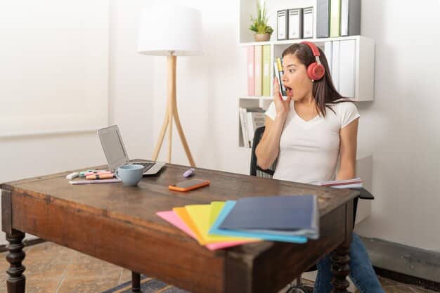 A person wearing noise-canceling headphones, sitting at a clean and organized desk with a single notebook and pen, completely absorbed in writing.
