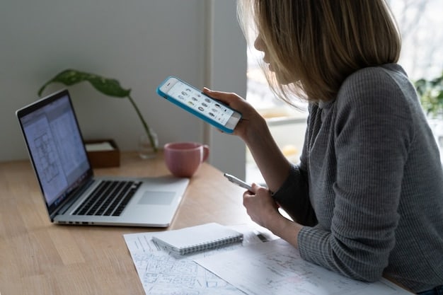 A person using a time tracking app on their smartphone while working on a laptop at a home office. The app shows detailed time spent on different tasks.