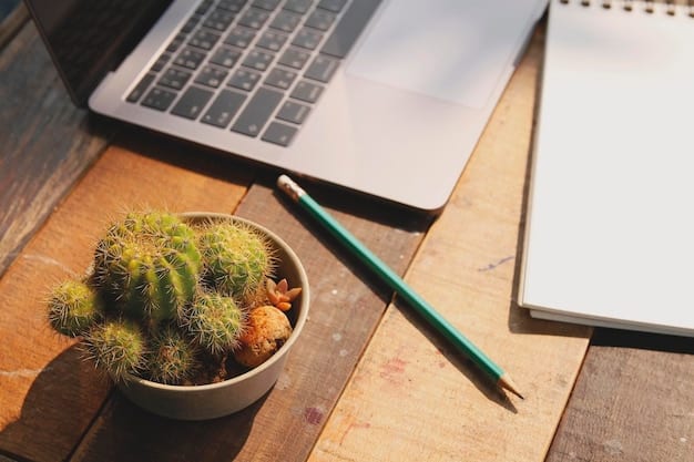 A close-up shot of a well-organized desk with a laptop, notebook, pen, and a small potted plant, highlighting a productive and comfortable workspace setup.