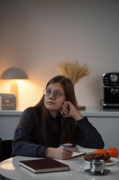 A person looking at a clock on their desk, seeming stressed. The lighting is dim and the expression suggests tiredness.