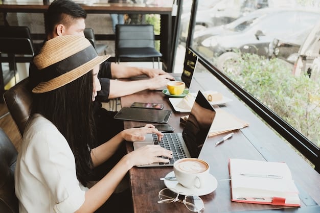 A digital nomad using a laptop in a cafe, surrounded by other people working remotely and chatting casually.