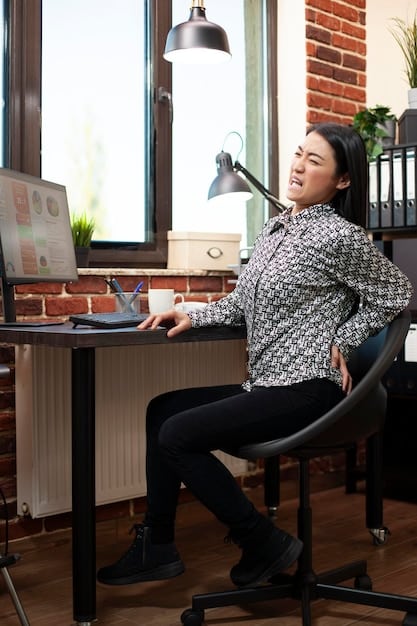 A person sitting comfortably at a desk with perfect posture, using an ergonomic chair with lumbar support. The chair is adjusted so the feet are flat on the floor, and the monitor is at eye level. The focus is on demonstrating proper ergonomic setup.