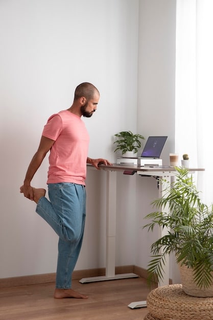 A person using a standing desk in a home office, taking a short break to stretch and practice mindfulness.