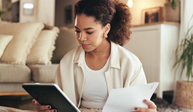 A freelancer reviewing a contract on her tablet with a financial calculator and various invoices spread on the table, highlighting the budgeting and organizational aspects of freelance contract management.